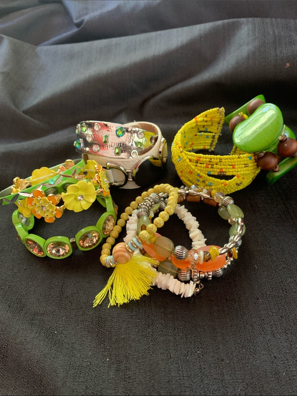 A collection of colorful bracelets yellow greens and silver FUN assortment